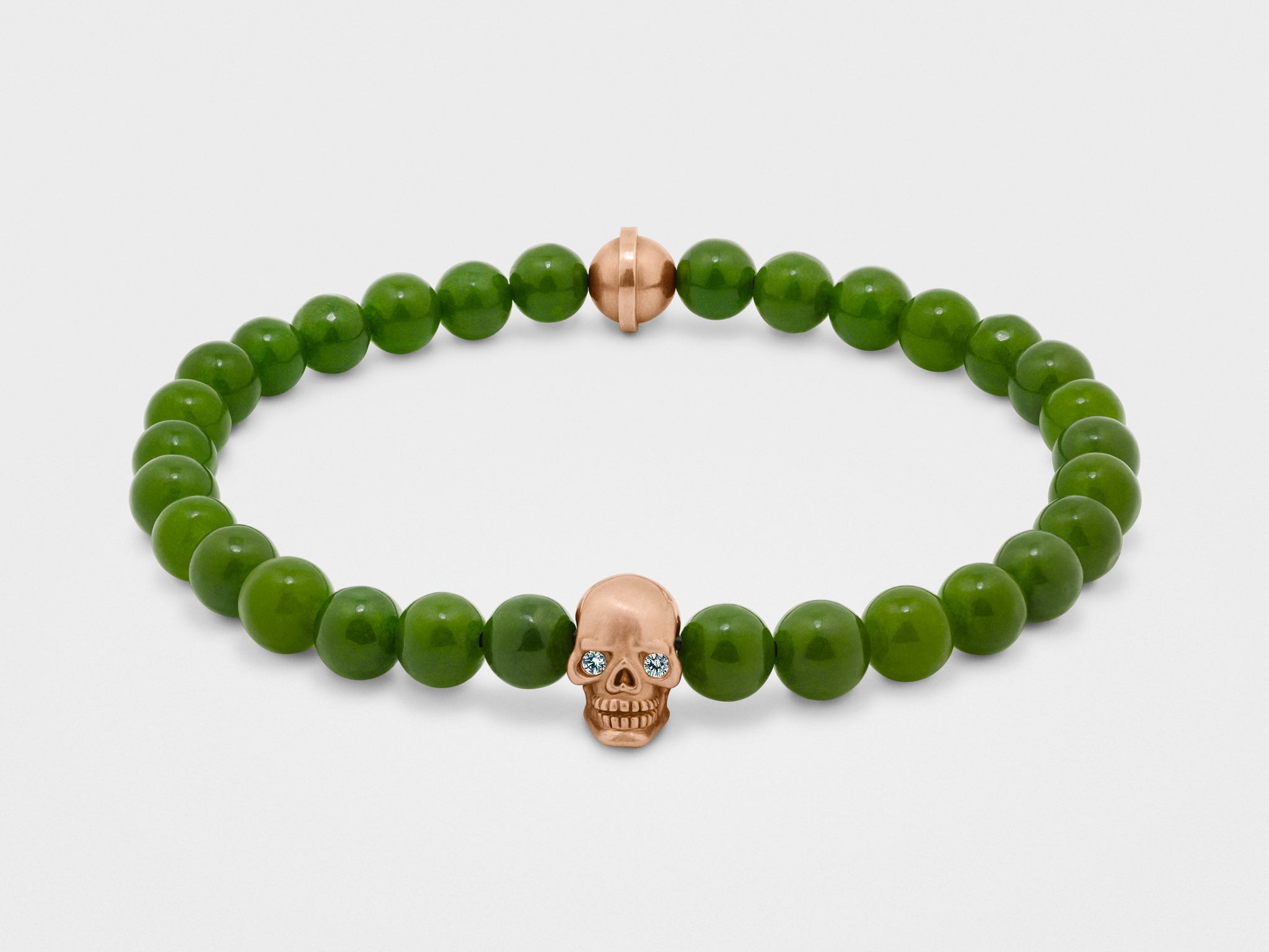 Pulsera de calavera en oro con ojos transparentes y cuenta verde